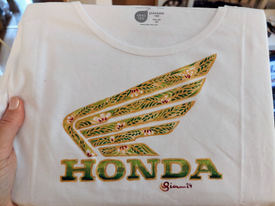 Honda Logo auf T-Shirt gemalt mit Goldrändern und grün-rot-weißem Blumen und Blätterornament